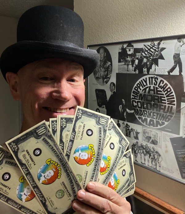 Carvin believes that to get user loyalty portal providers should share their revenues with their users. Here James Carvin holds up a fist full of Ǥhost Bucks.